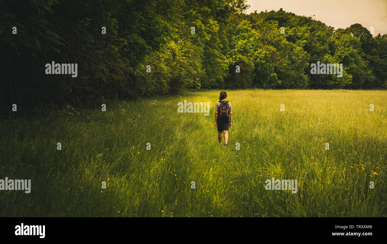 Young woman walking in a field Banque D'Images