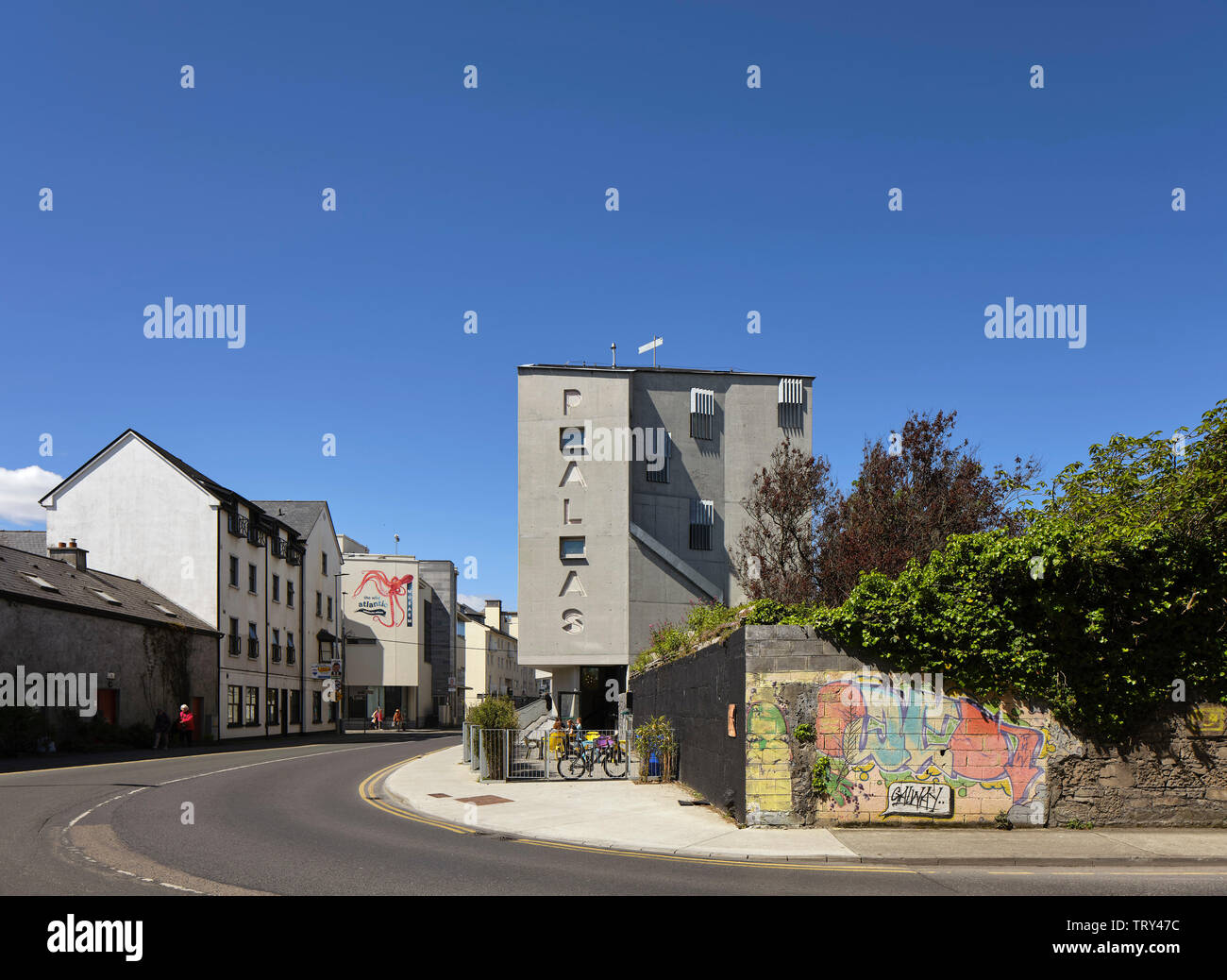 Street view lointain avec cinema's nom gravé dans la façade en béton. Pálás Cinéma, Galway, Irlande. Architecte : dePaor, 2017. Banque D'Images