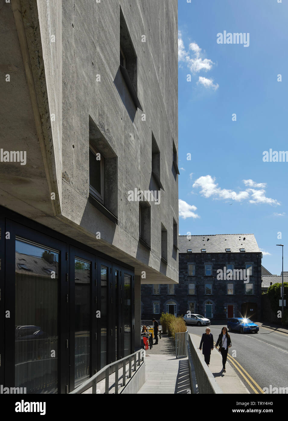 Le long de la perspective façade rue en béton avec rampe d'entrée et café à l'extérieur. Pálás Cinéma, Galway, Irlande. Architecte : dePaor, 2017. Banque D'Images