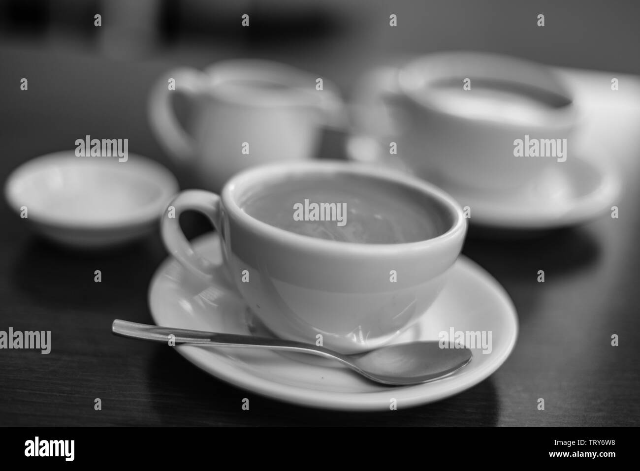 Tasses de café avec du lait pot sur une table avec bokeh Banque D'Images Tasses de café avec du lait pot sur une table avec bokeh Banque D'Images