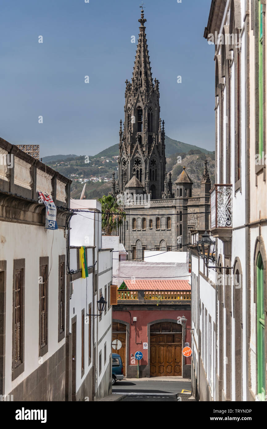 Der Blick durch eine Gasse auf einen Turm der Kirche San Juan Bautista en Arucas auf Gran Canaria Banque D'Images