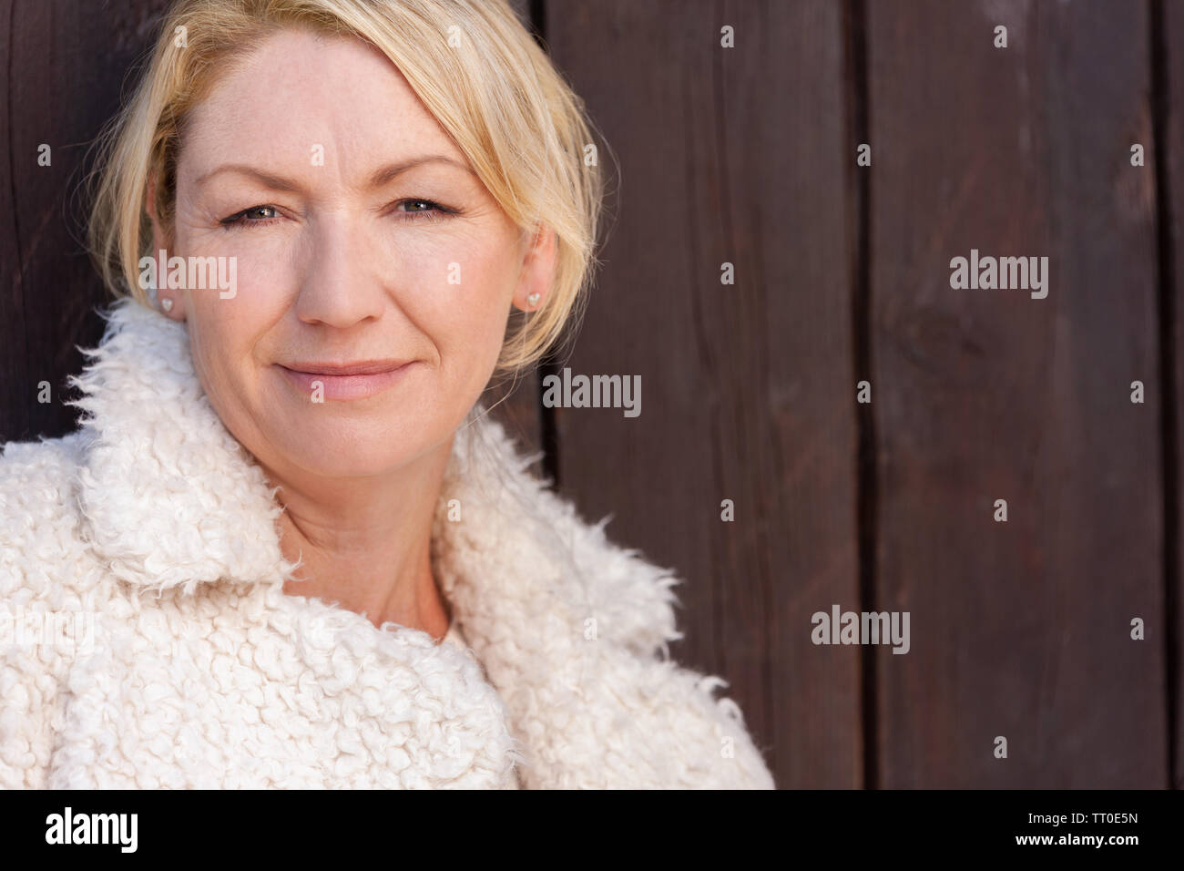 Belle femme d'âge moyen réfléchi leaning reposant contre une clôture en bois Banque D'Images