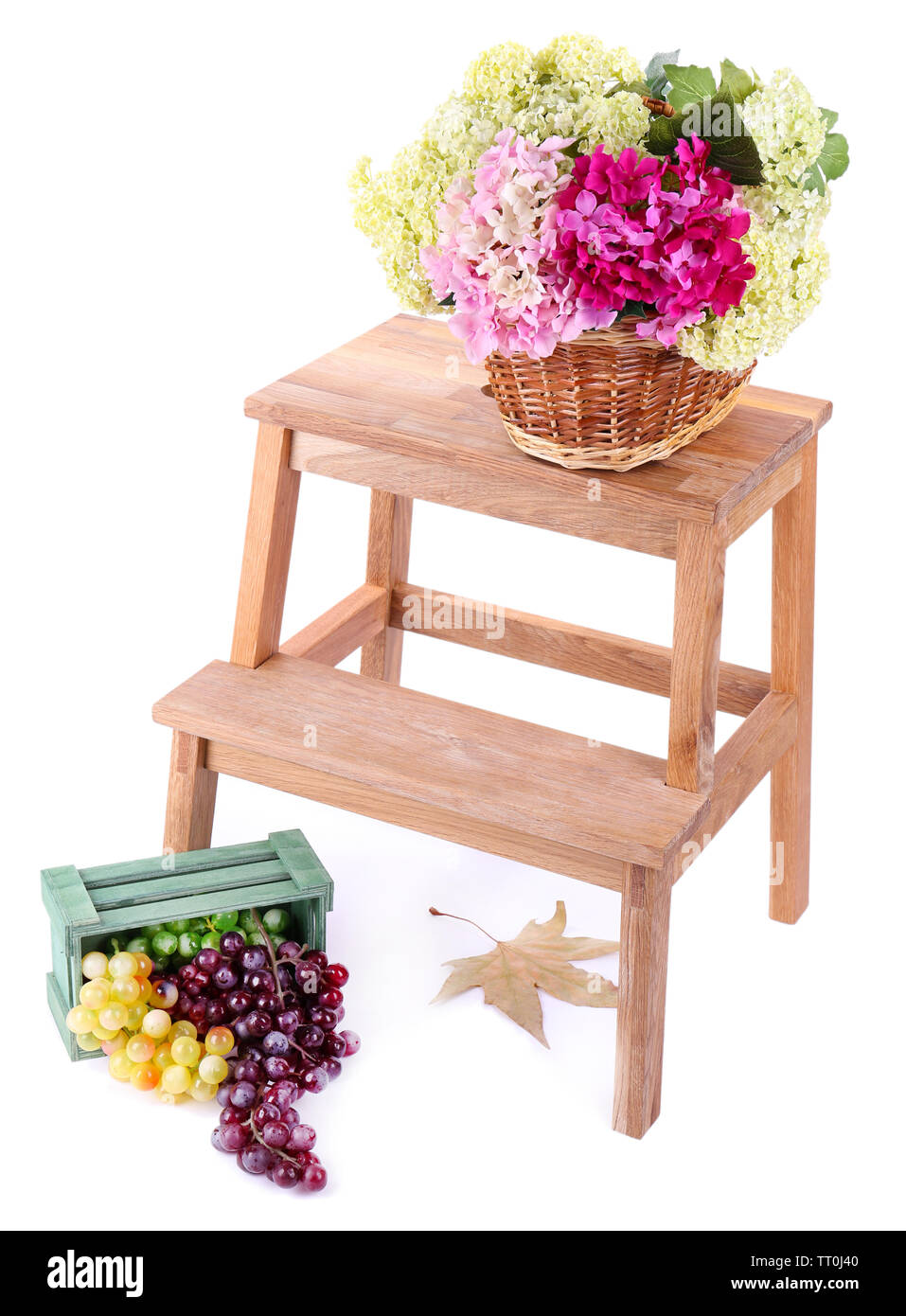 Panier en osier avec des fleurs et des fruits en boîte en bois, sur la petite échelle en bois, isolé sur blanc Banque D'Images