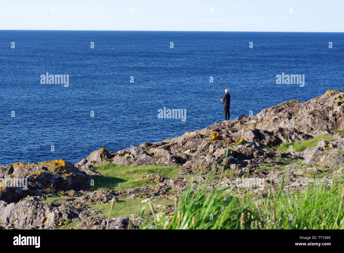 Pêcheur sur les falaises à Eyemouth, une petite ville et une paroisse civile dans le Berwickshire, dans la région des Scottish Borders Banque D'Images