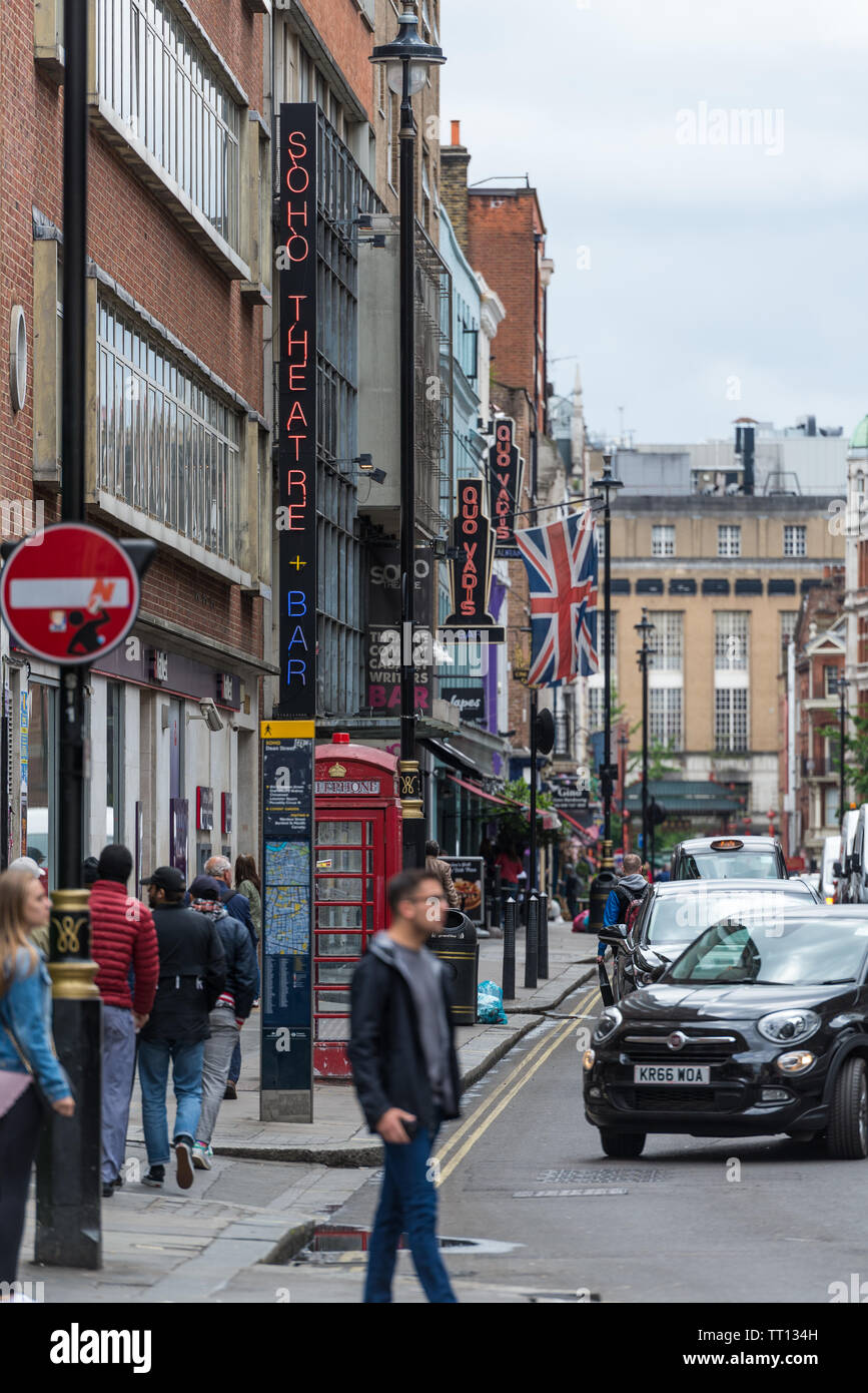 Vue générale le long de la rue Doyen avec néon panneaux pour Quo Vadis Soho Theatre Restaurant et Bar, Soho, Londres. Le trafic routier et les gens dans la rue Banque D'Images