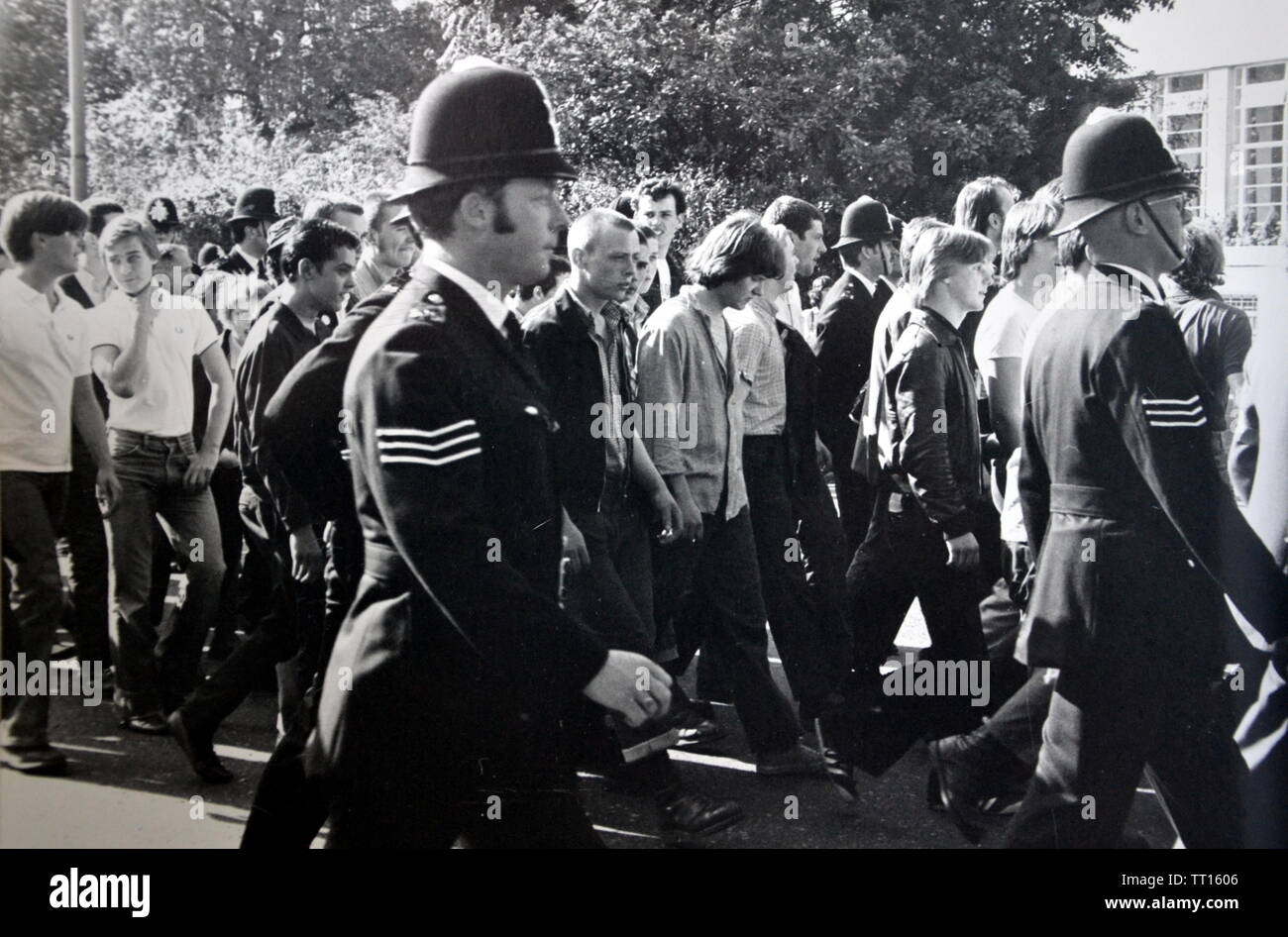 Les jeunes hommes participent à une Marche nationale du Front, Londres, Angleterre, entourée de policiers, au milieu des années 1970 Banque D'Images