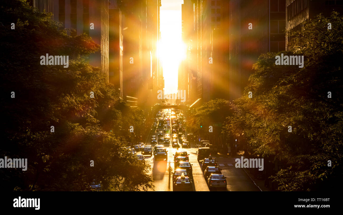 Rayons du soleil sur les voitures et les bâtiments le long de la 42e Rue, en plein centre de New York Banque D'Images