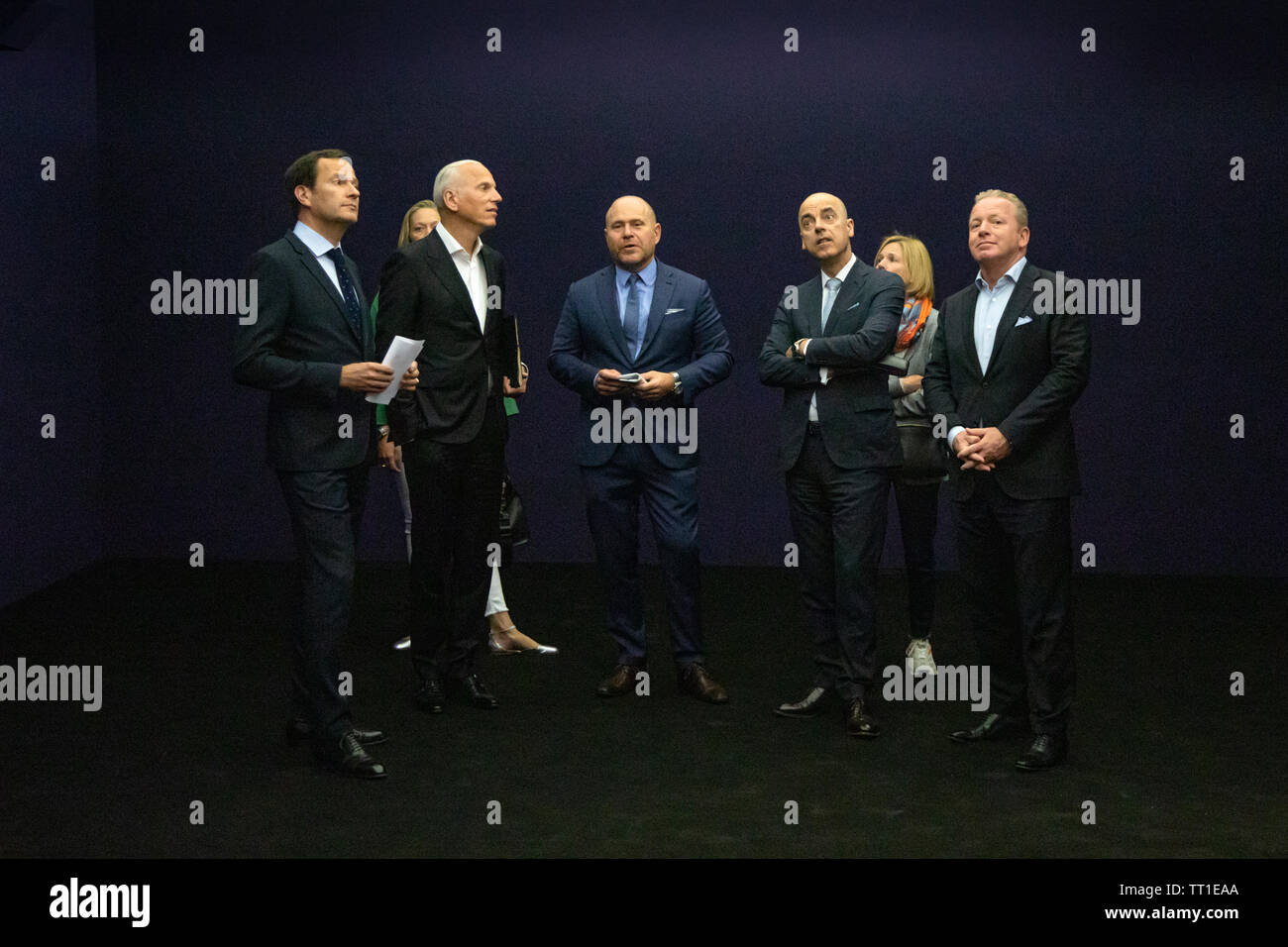 Directeur mondial de l'Art Basel Marc Spiegler (centre) de discuter d'une pièce d'art par l'artiste italien Lucio Fontana avec un groupe de clients VIP à la 49e Annual Art Basel Art fair à Bâle. Banque D'Images