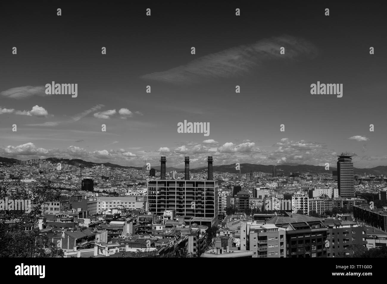 Le noir et blanc vue du quartier Poble Sec de Barcelone, les nuages se déplacent sur cityscape, montagnes en arrière-plan. Banque D'Images
