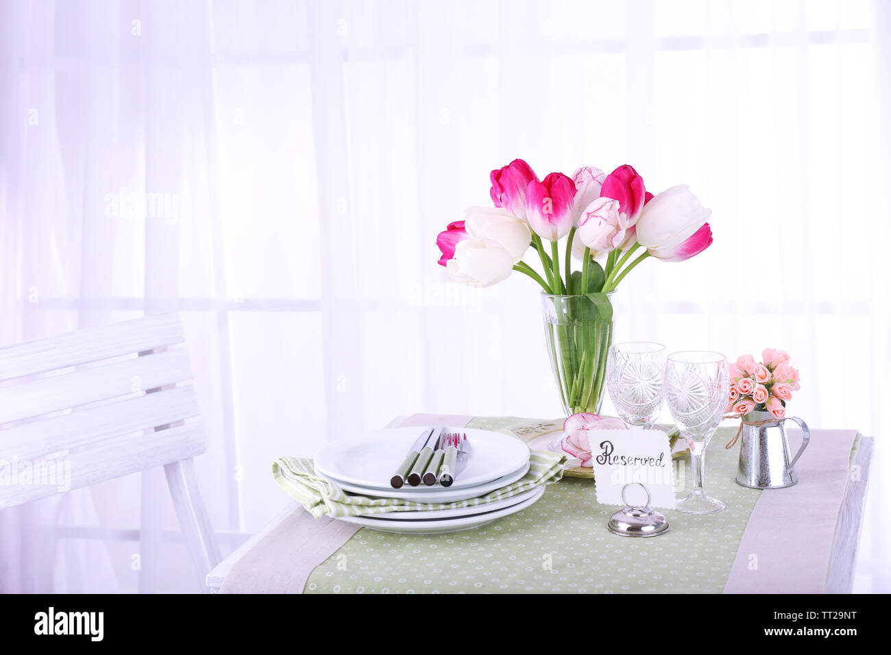 Nouvelle table et chaises avec des couverts sur fond clair Banque D'Images