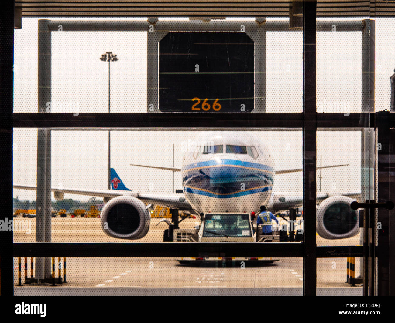 , BAIYUN de Guangzhou, Chine - 10 MAR 2019 - China Southern Airlines avion vu à travers la porte d'embarquement à l'Aéroport Baiyun de fenêtre Banque D'Images