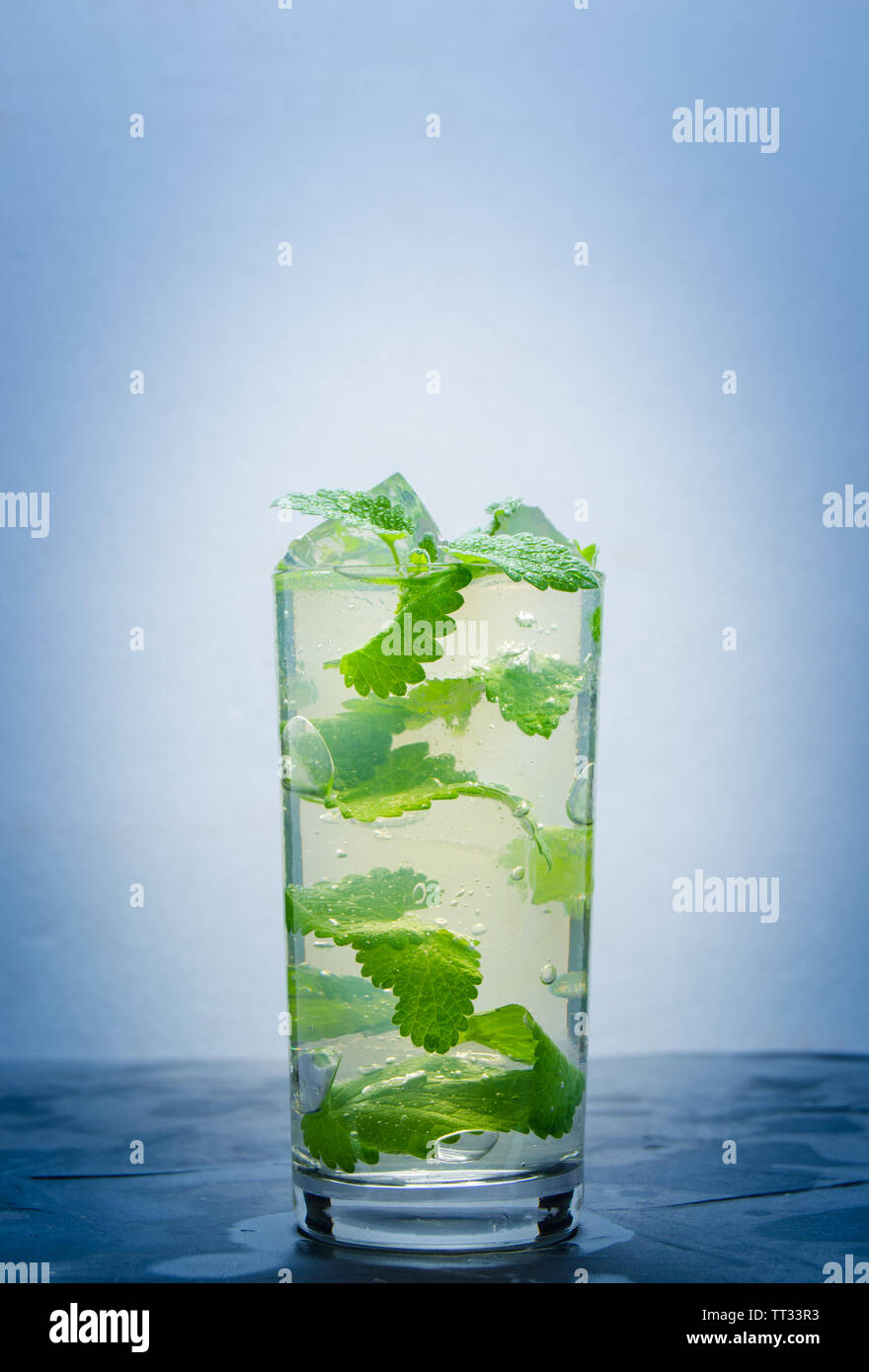 L'eau fraîche dans un verre de glace et pétales menthe.Soft drink, avec le vignetage. Banque D'Images