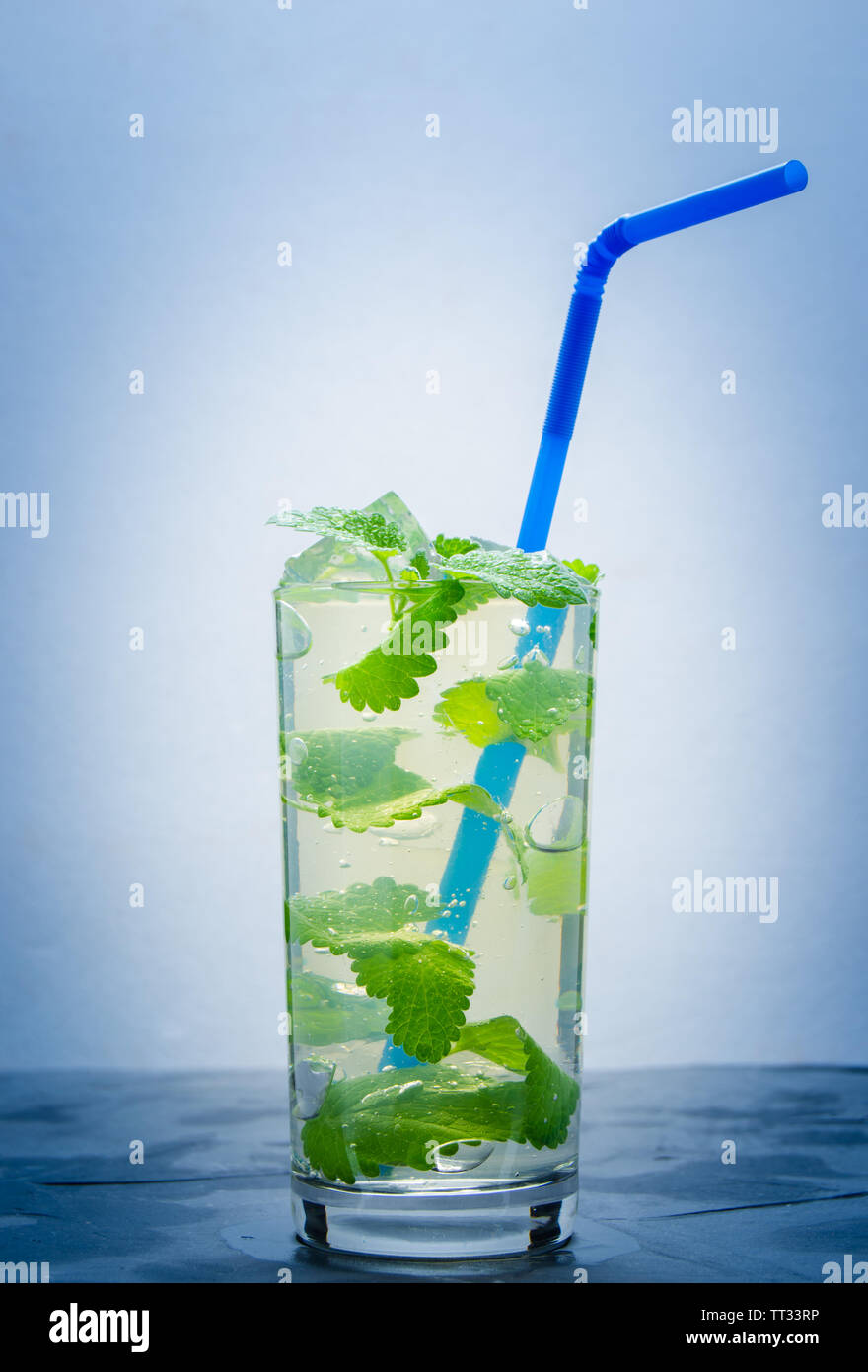 L'eau fraîche dans un verre de glace et pétales menthe.Soft drink, avec le vignetage. Banque D'Images