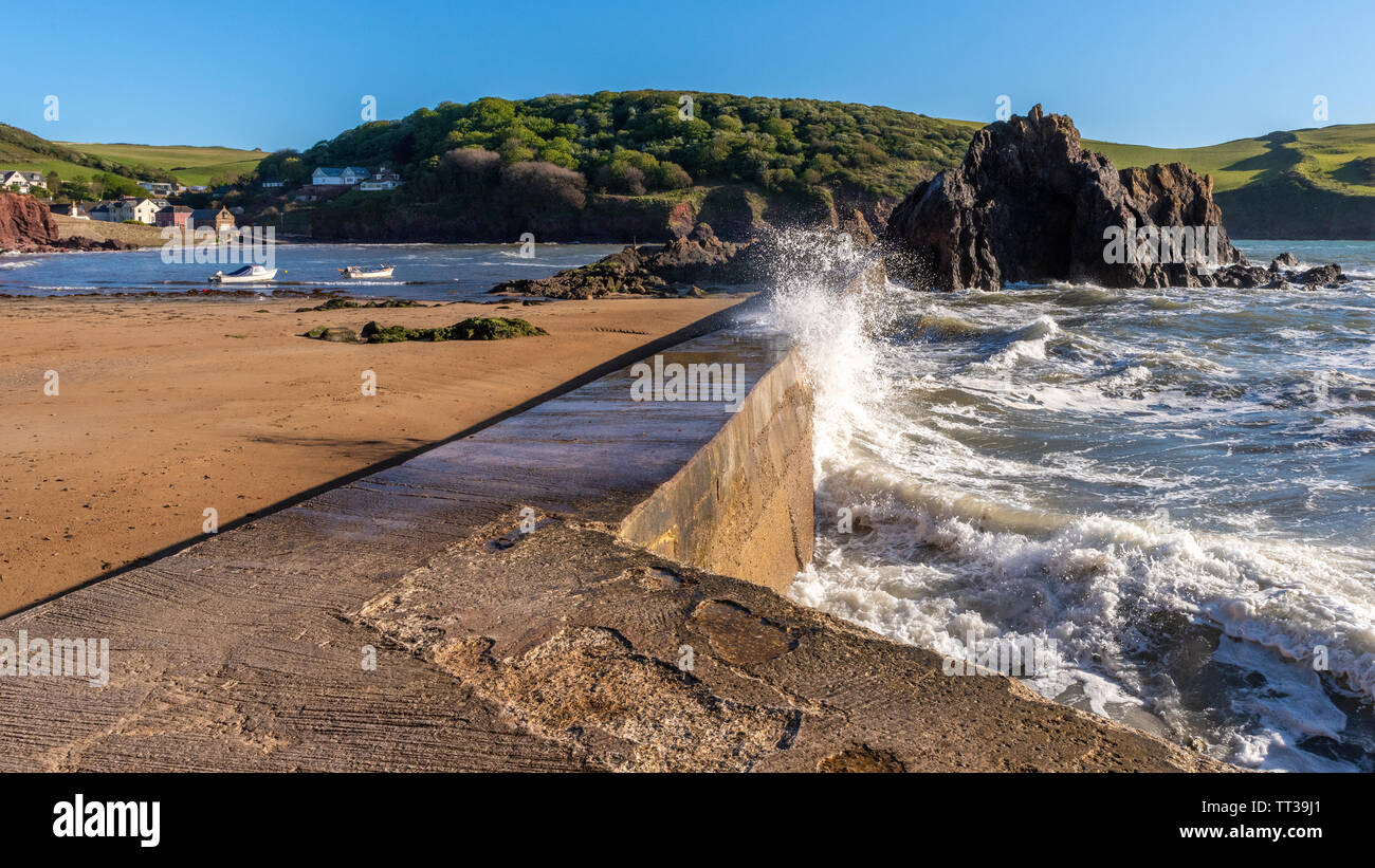 Vague et brise-lames, Hope Cove, Devon Banque D'Images