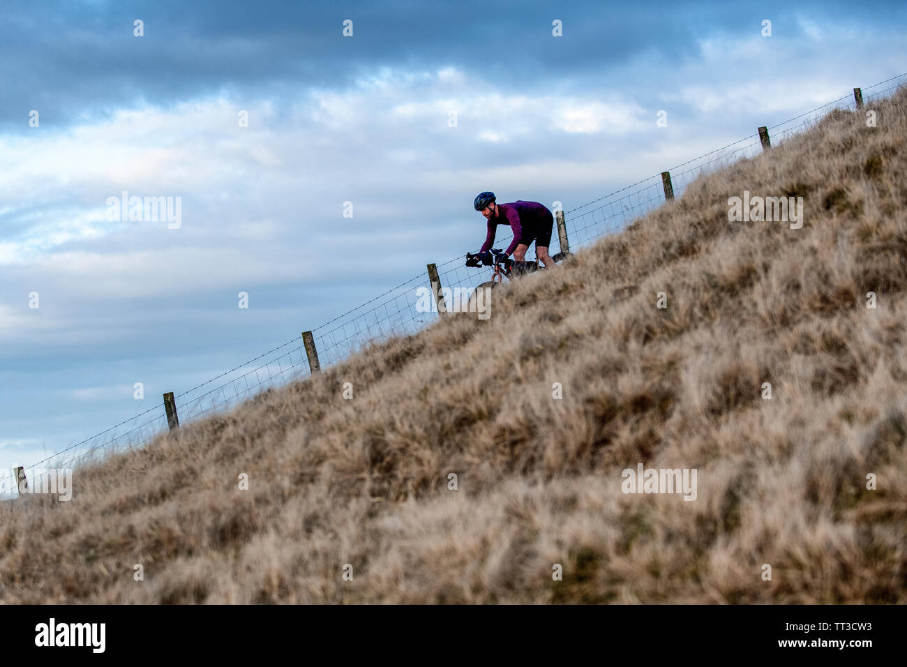 Un homme monte un touring bike off road dans le Parc National de Northumberland. Banque D'Images