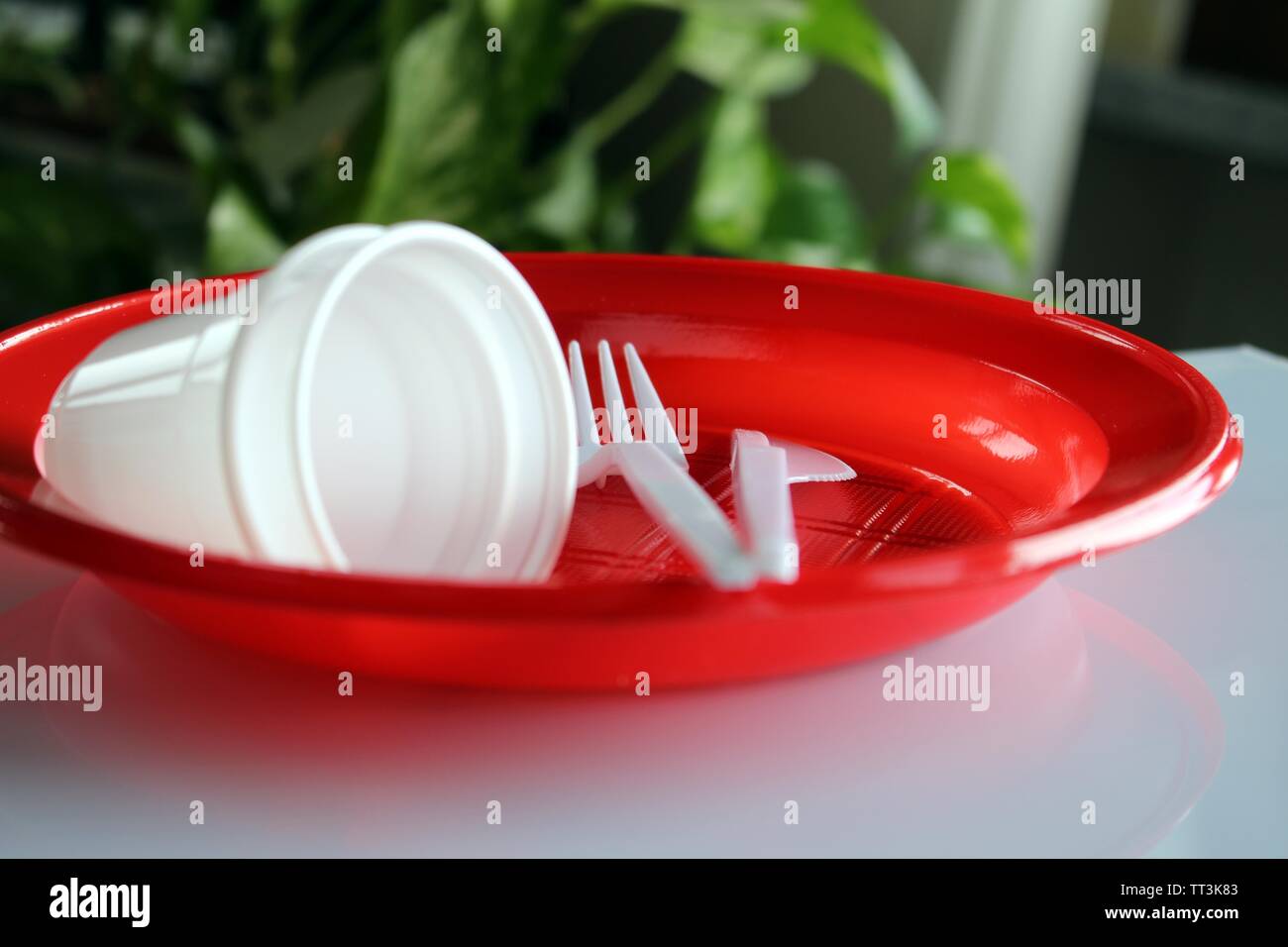 Groupe de plaques avec des verres en plastique jetables et fourches Banque D'Images