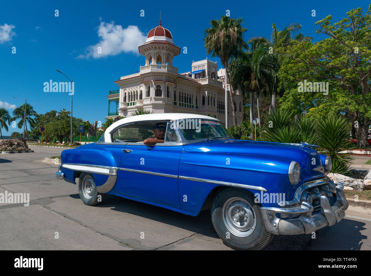 1950 American voiture conduit au-delà du Palacio de Valle, maintenant un restaurant, sur la Punta Gorda, Cienfuegos, Cuba Banque D'Images