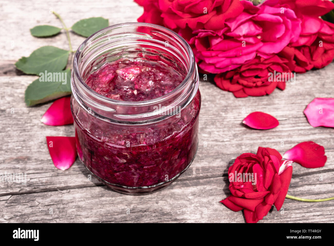 Pot de confiture de pétales de rose sur une table en bois avec des fleurs de roses. Confiture de fleurs. Alimentation saine. Copy space Banque D'Images