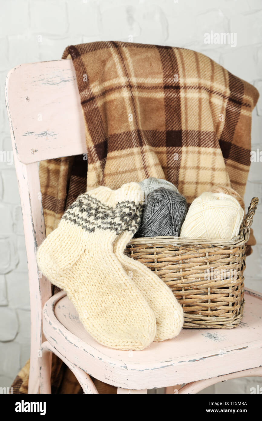 Nature morte avec fil à tricoter et des chaussettes sur chaise en bois Banque D'Images