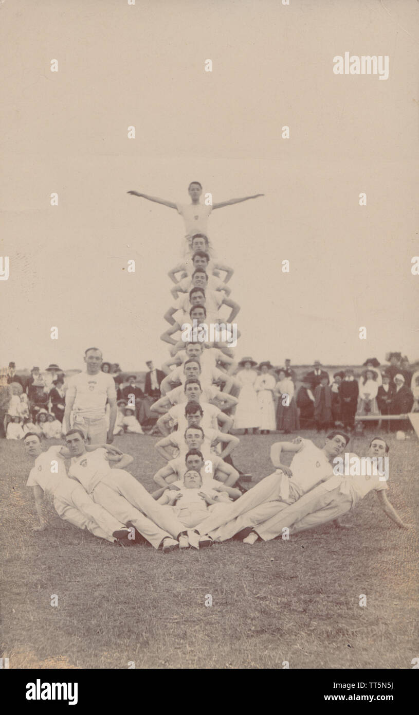 Vintage Edwardian / début du 20e siècle Carte postale photographique d'une équipe d'effectuer des épreuves de gymnastique, lors d'un événement public. Banque D'Images