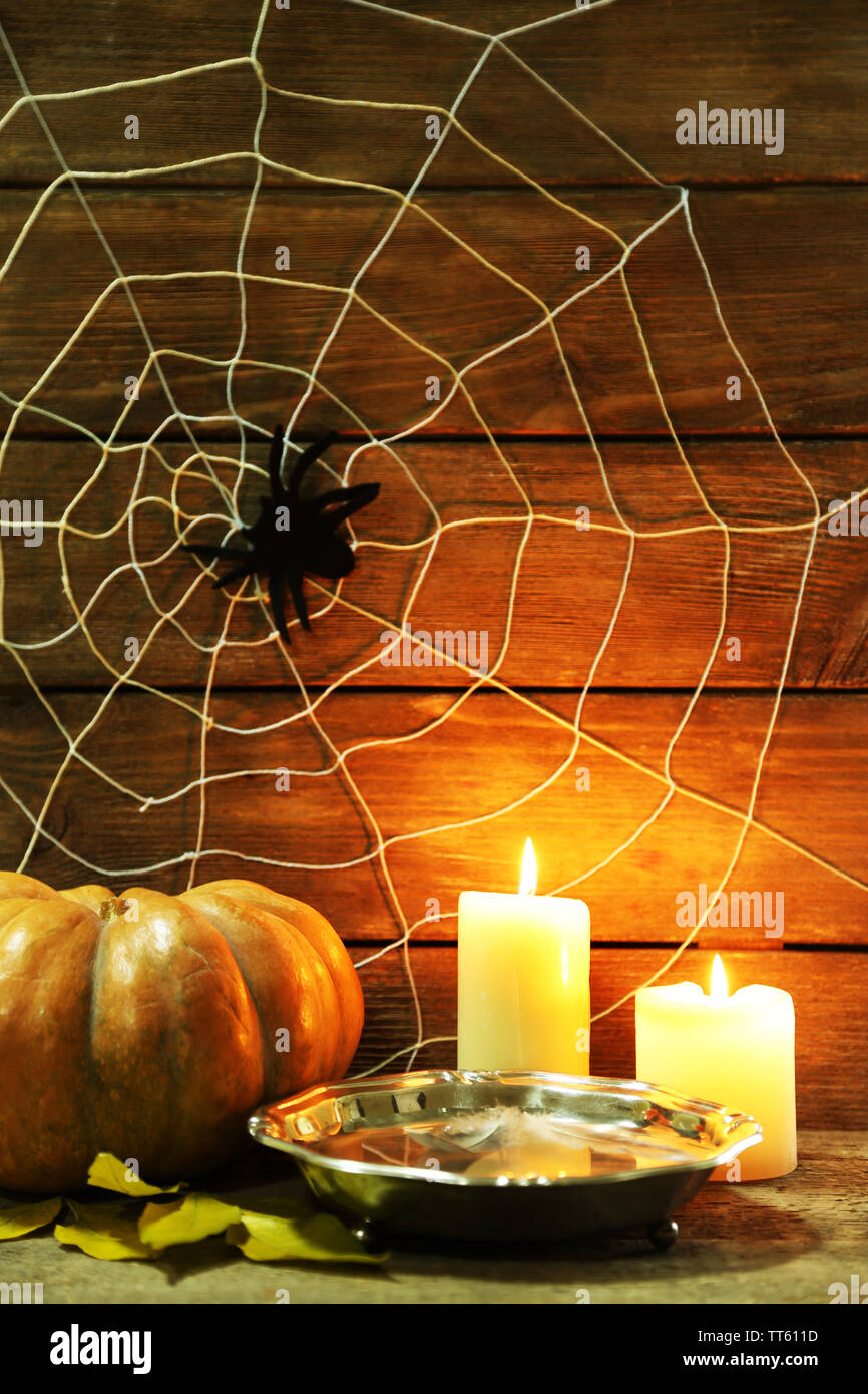 Décoration Halloween avec spider on web, la citrouille et les bougies sur fond de bois Banque D'Images