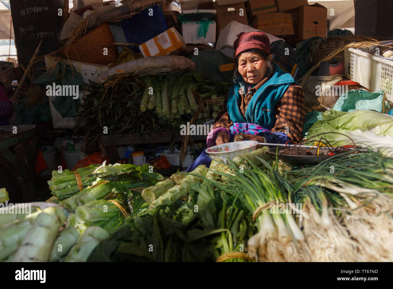 01 févr. 2017- Dali, Chine ancien dame vend des verts au marché local Banque D'Images