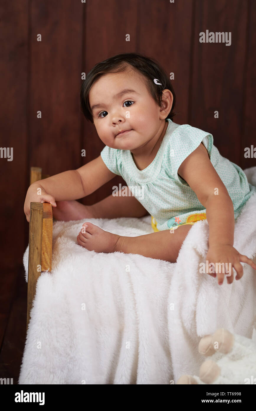 Portrait of cute little baby girl sur fond de studio en bois sombre. Banque D'Images