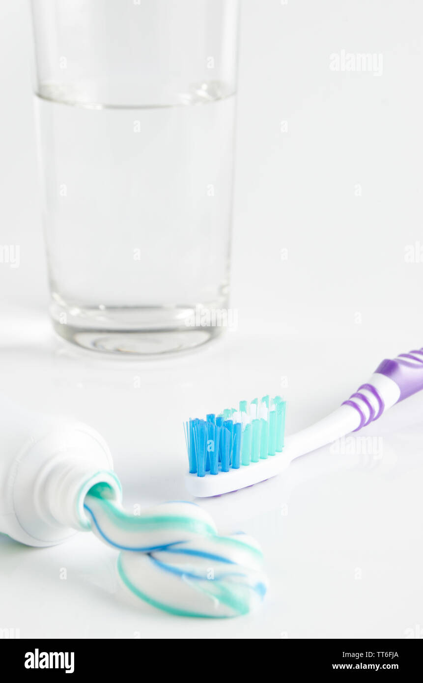 Tube de dentifrice, brosse à dents et un verre sur un fond blanc Banque D'Images