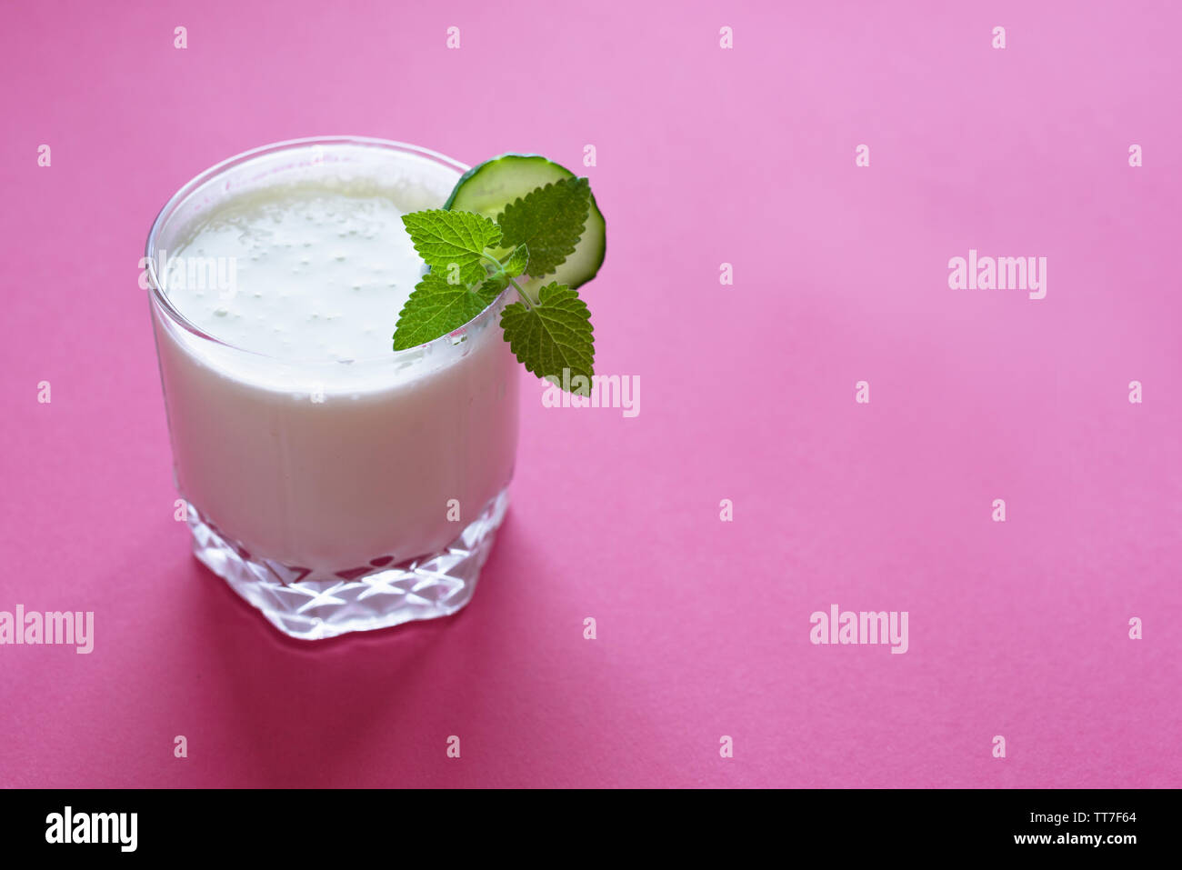 Boisson au yogourt (ayran, kéfir, lassi) dans du verre - l'été en bonne santé boisson fraîche sur rose, copiez l'espace. Banque D'Images