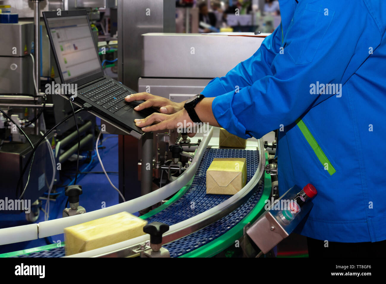 Ingénieur de fabrication utilisé pour contrôler l'ordinateur du système d'inspection de produits machine d'automatisation en usine moderne alors que les produits se déplacent sur la transmettre Banque D'Images