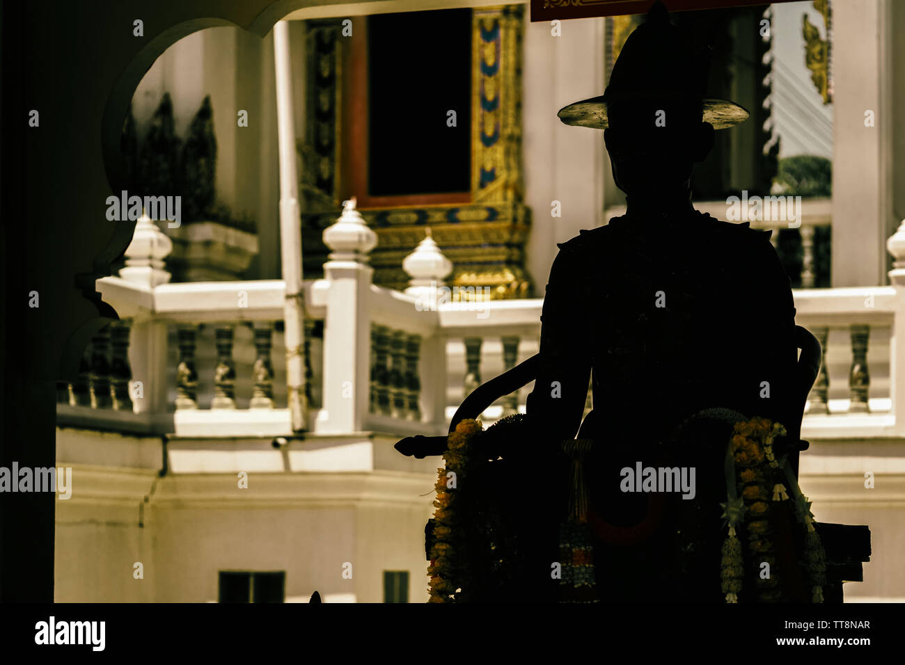 La sombre silhouette de la statue d'un soldat thaïlandais,qui est assis en face d'un Wat. Banque D'Images