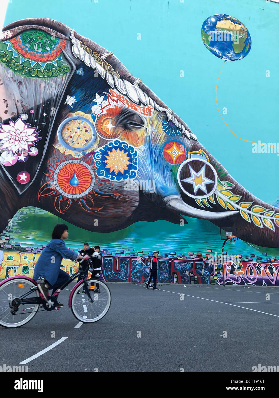 Berlin, Allemagne - Juin 2019 : des enfants qui jouent en plein air, sur le terrain de soccer de rue avec peinture murale graffiti en arrière-plan à Berlin, Kreuzberg Banque D'Images