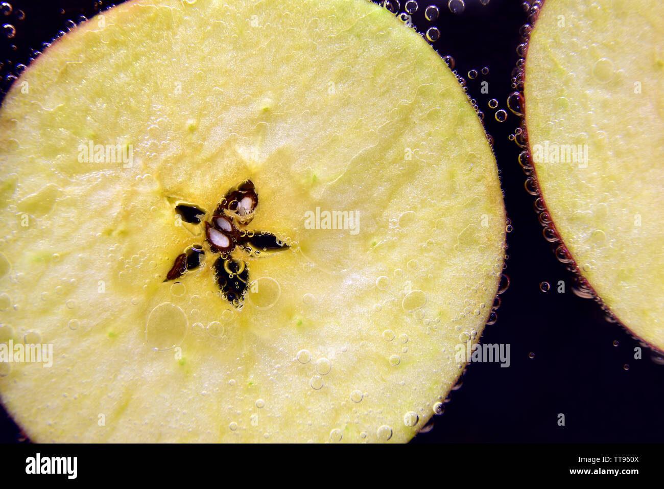 Close up de tranches de pomme sous l'eau avec des bulles Banque D'Images