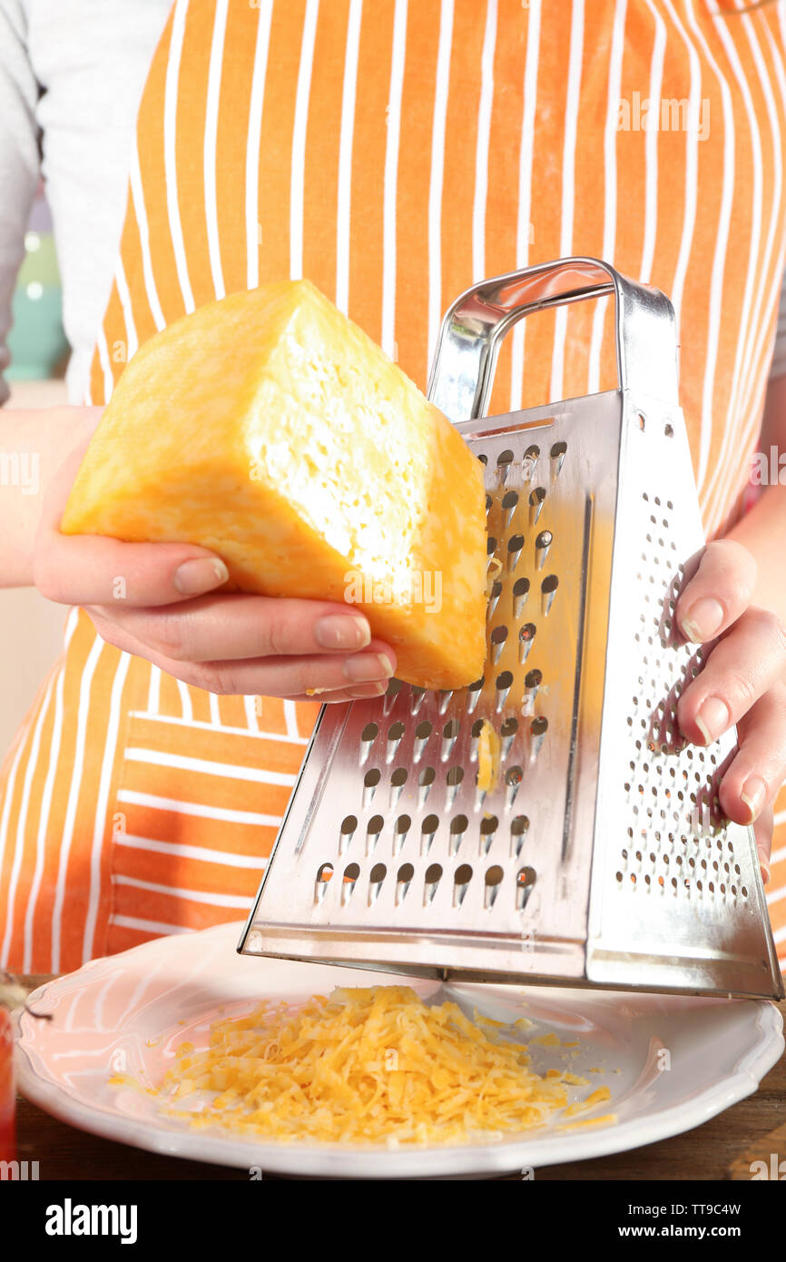 Gros plan du fromage râper les mains des femmes Banque D'Images