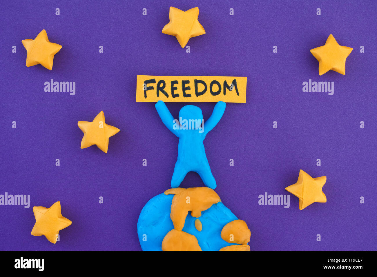 Personne debout sur la planète Terre et en maintenant le mot liberté. Notion de droit. Personne et la planète terre sont faits de pâte à modeler l'argile (jouer). Banque D'Images