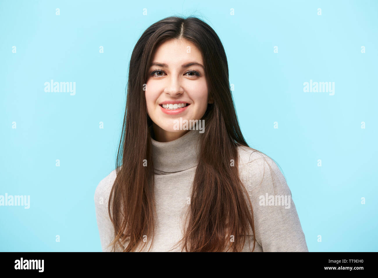 Portrait d'une belle jeune femme de race blanche, heureux et souriants, looking at camera, isolé sur fond bleu Banque D'Images