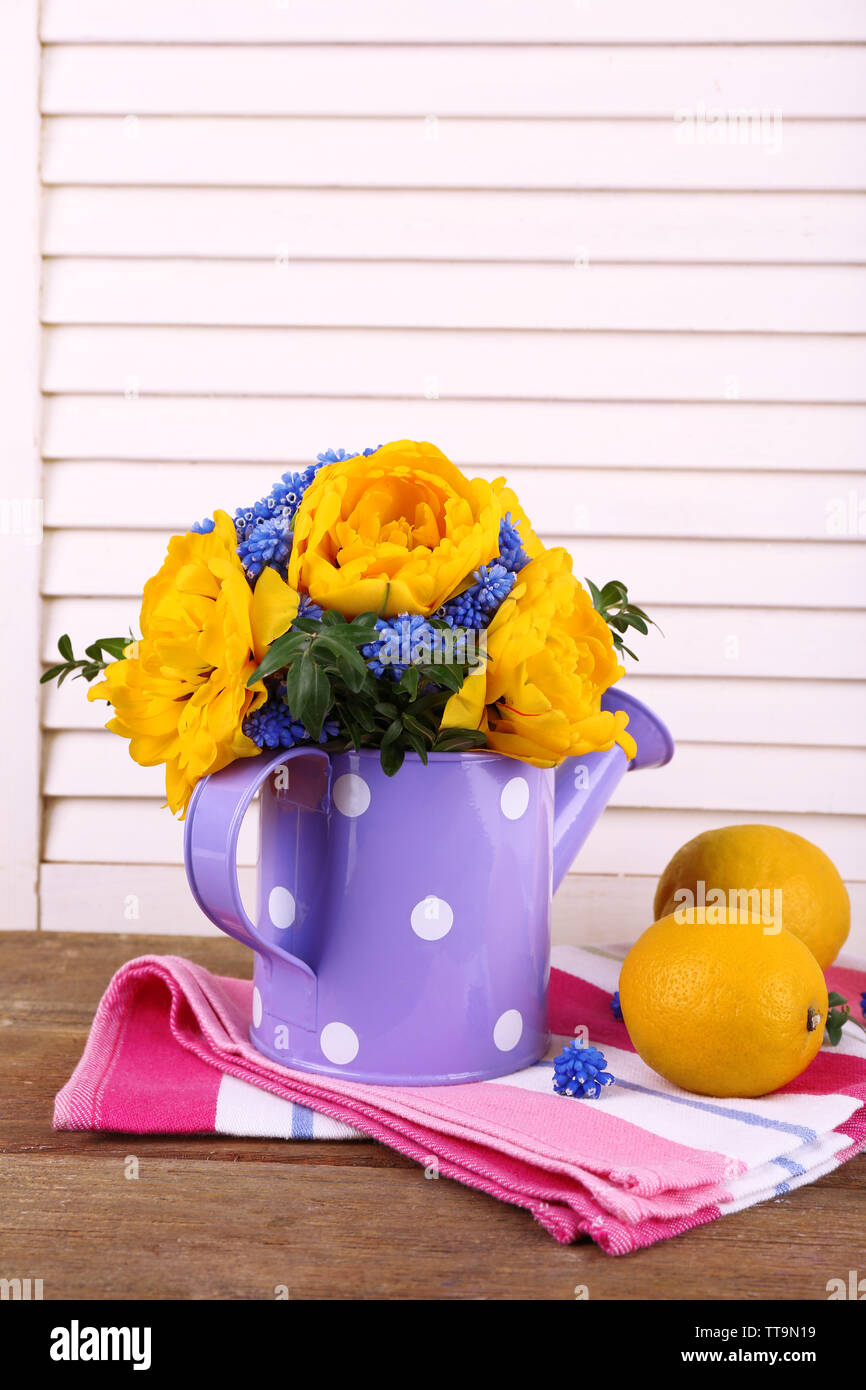 La composition avec des fleurs de printemps dans l'eau sur fond de bois Banque D'Images