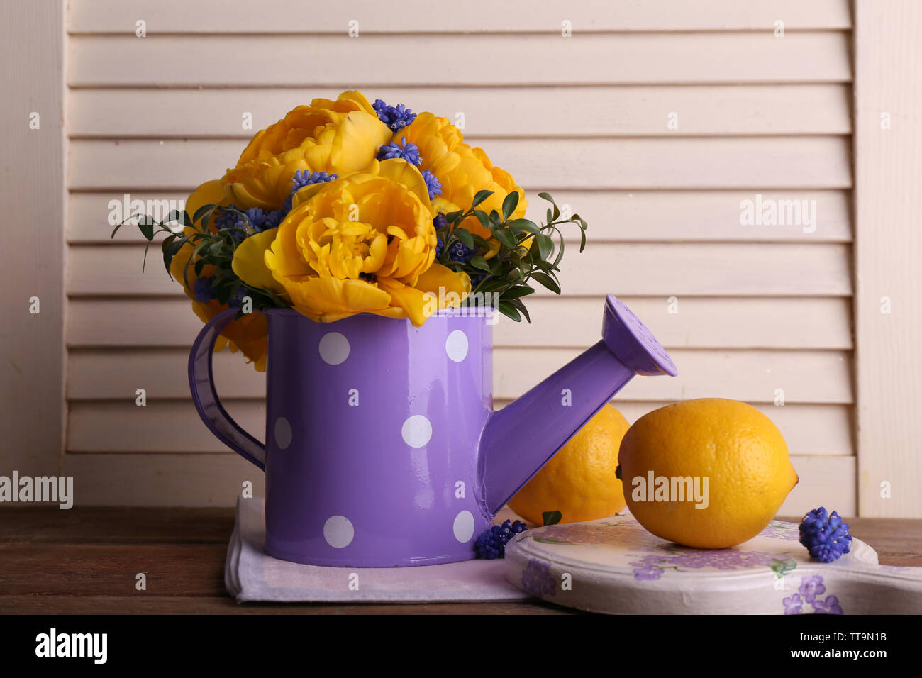 La composition avec des fleurs de printemps dans l'eau sur fond de bois Banque D'Images