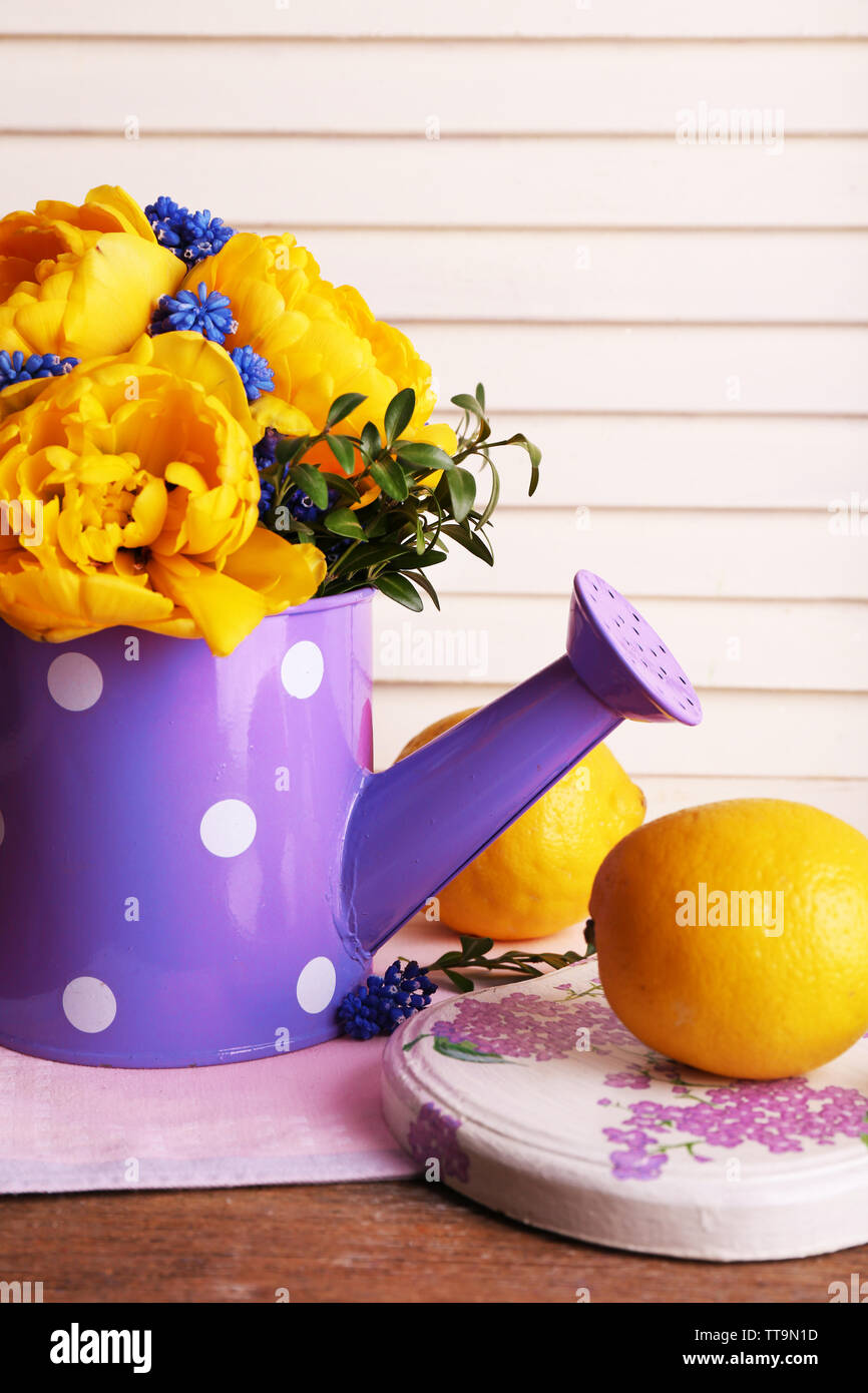 La composition avec des fleurs de printemps dans l'eau sur fond de bois Banque D'Images