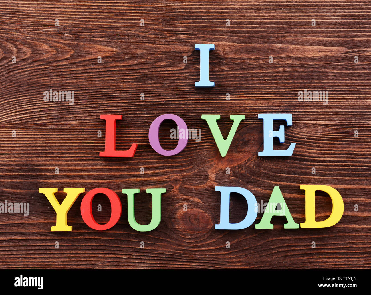 Inscription J'AIME Papa fait de lettres colorées sur fond de bois Banque D'Images