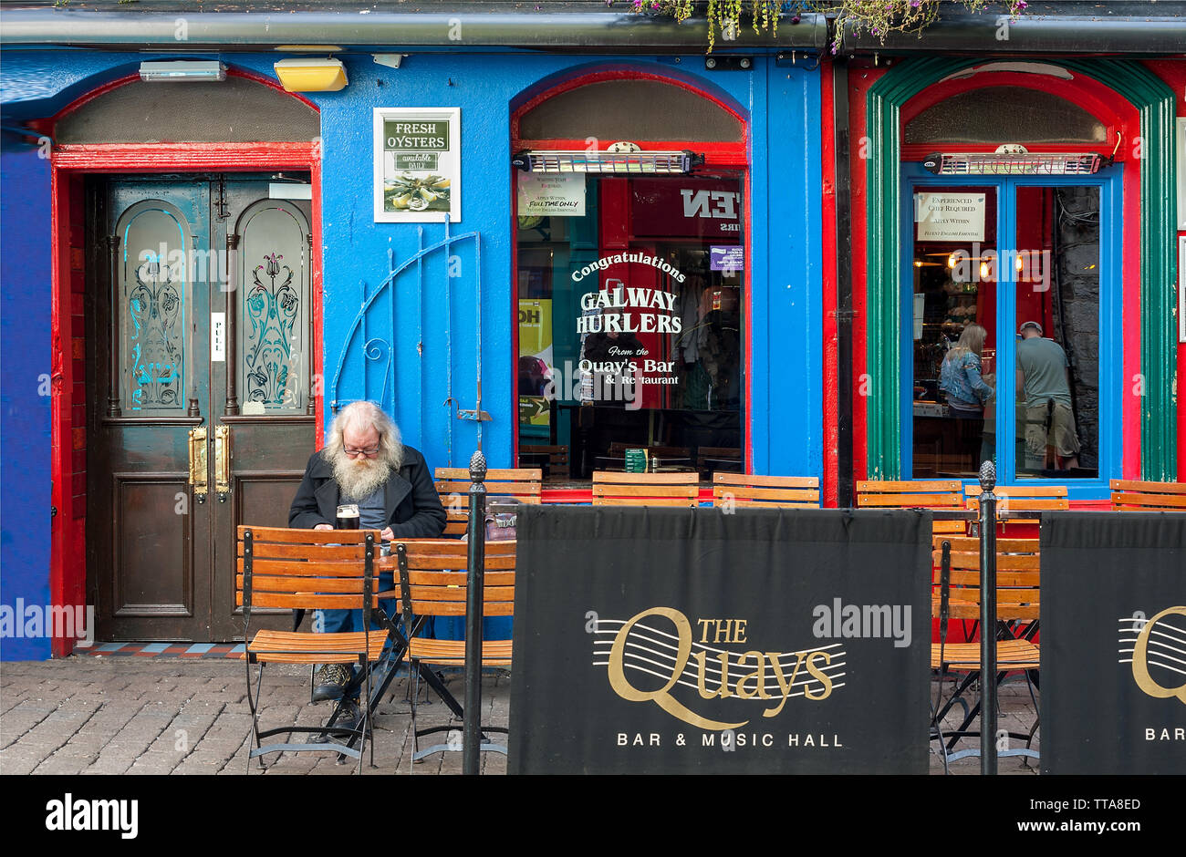 Homme barbu assis seul à l'extérieur patio pub Banque D'Images