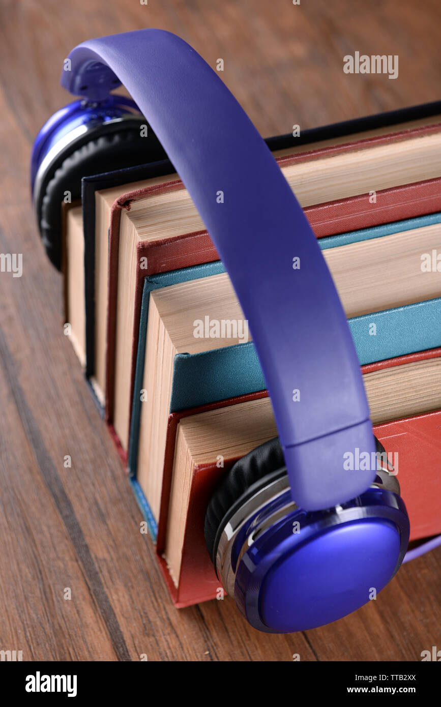 Livres et livres audio écouteurs comme concept sur table en bois, gros plan Banque D'Images