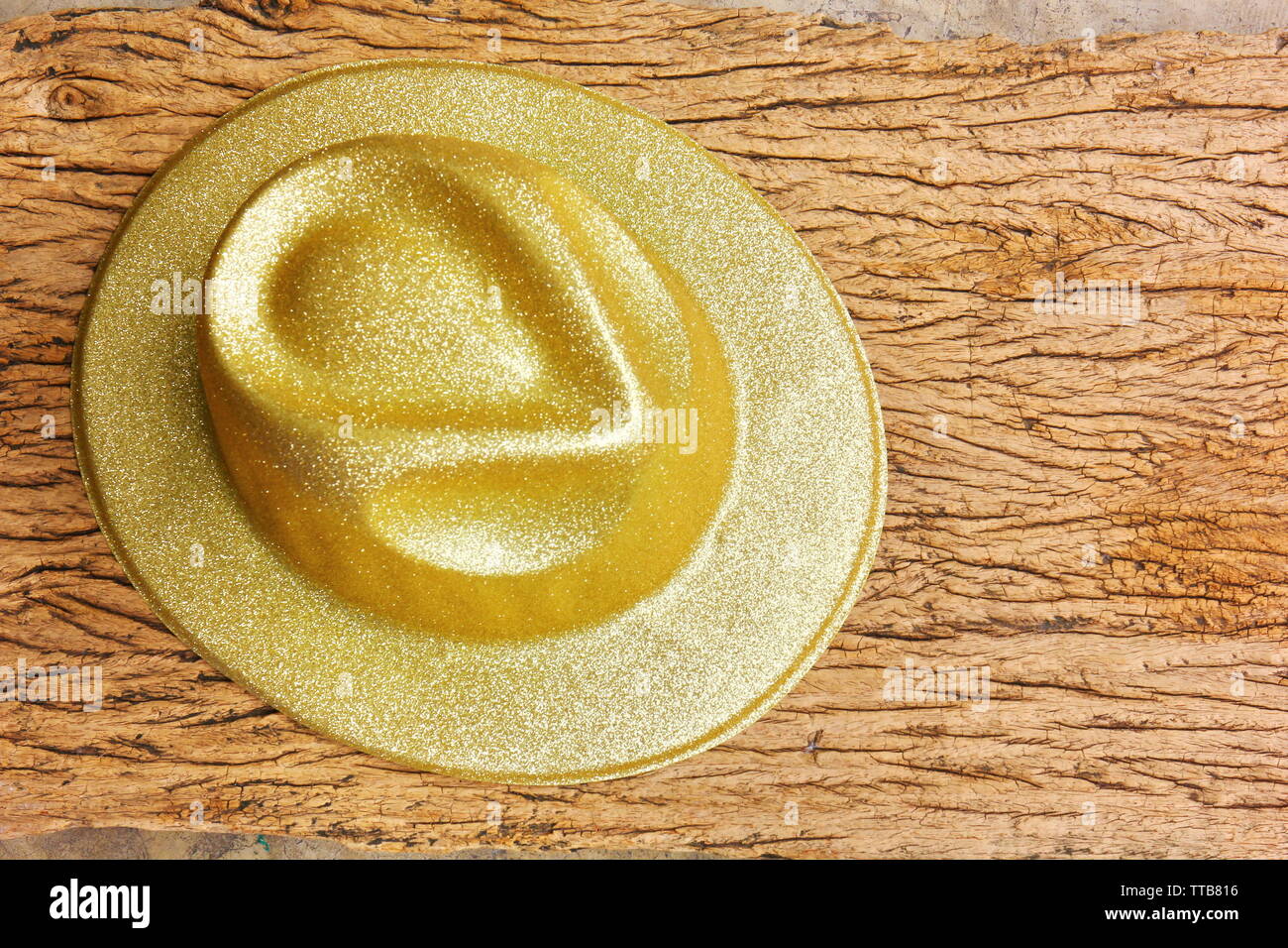 Fantaisie en plastique doré sur fond de bois vintage hat.golden hat dans fantaisie new year party Banque D'Images