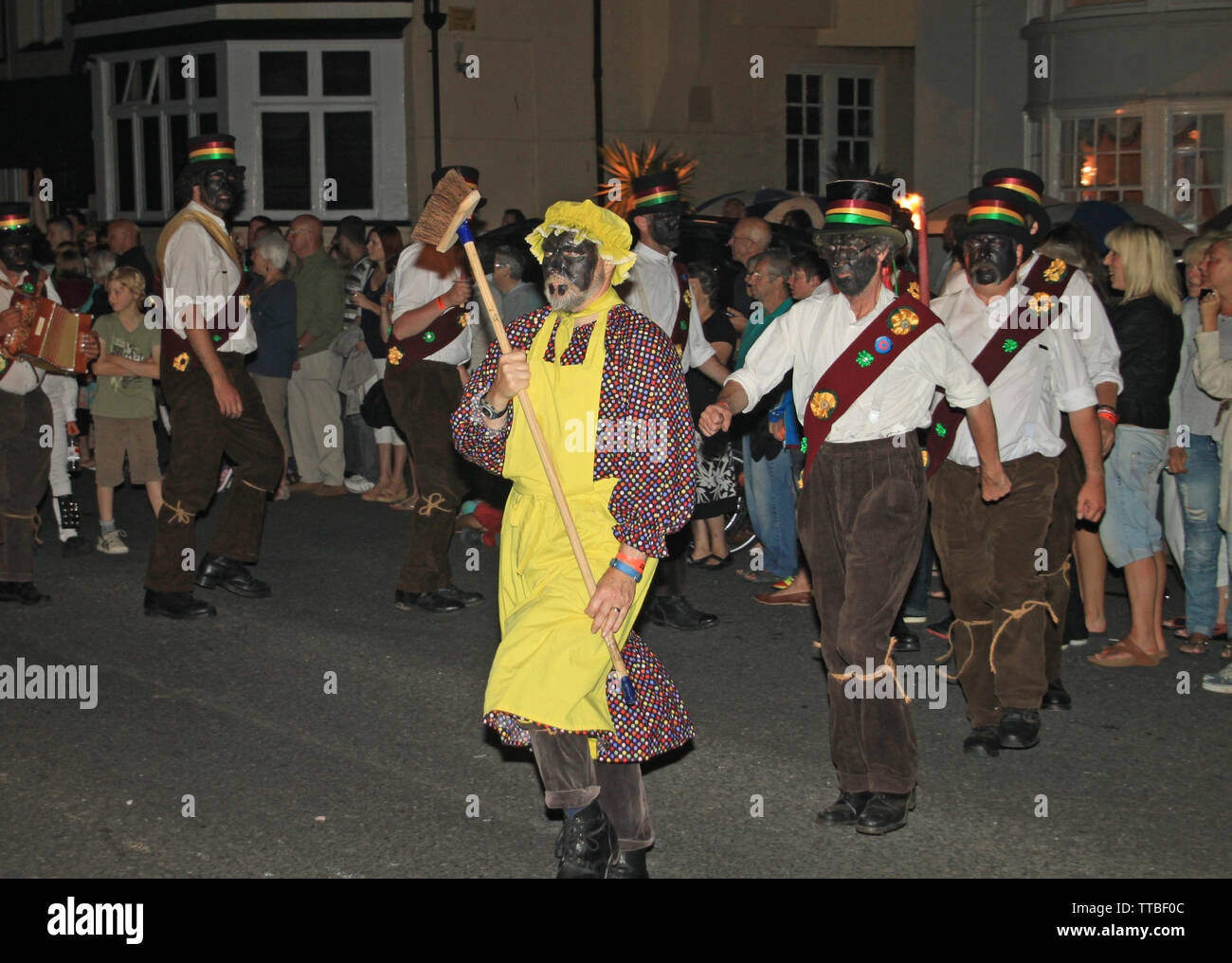La ville de Sidmouth, Devon, Angleterre - 10 août 2012 : Un troup de danseurs Morris anglais traditionnel dirigé par un homme avec un balai et d'un tablier jaune prend part à Banque D'Images