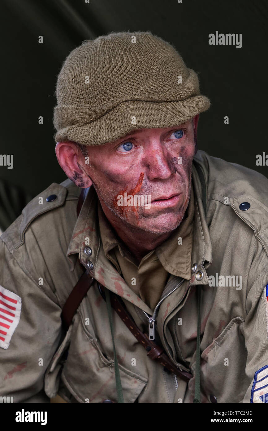 Un reenactor habillé comme un soldat de l'Armée U.S 82nd Airborne Division "tous Américains" avec du faux sang sur son visage Banque D'Images