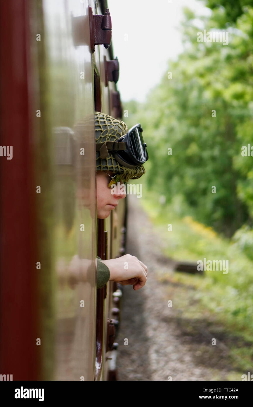 Un homme habillé en uniforme militaire se penchant hors de la fenêtre d'un wagon de chemin de fer Banque D'Images