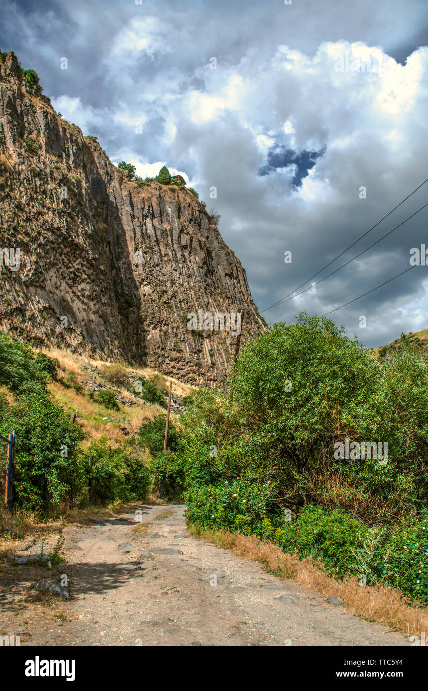 Le ciel sombre de la grosse tempête nuages sur la gorge Garni et la route en passant sur les roches basaltiques permanent verticalement et collines Banque D'Images