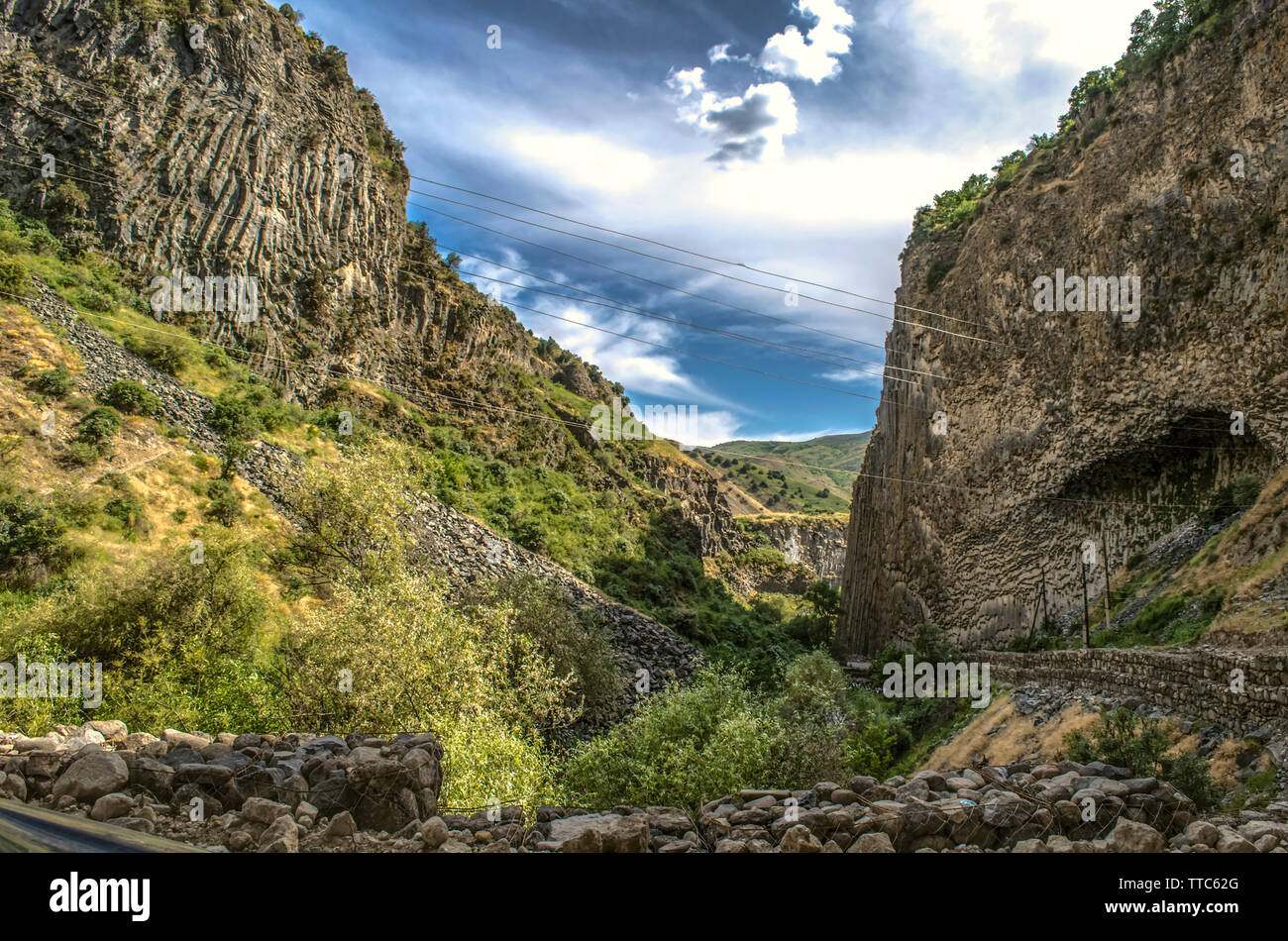 Belle vue sur la route de montagne à travers la gorge Garni recouvert d'arbustes et d'herbe verte sur les collines et les roches basaltiques en position verticale Banque D'Images