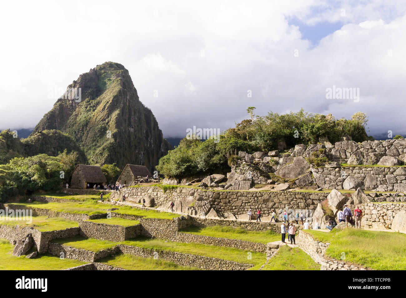 Le Machu Picchu au Pérou - Touristes marcher autour de la citadelle de Machu Picchu, avec vue sur la montagne Huayna Picchu en arrière-plan, le Pérou. Banque D'Images