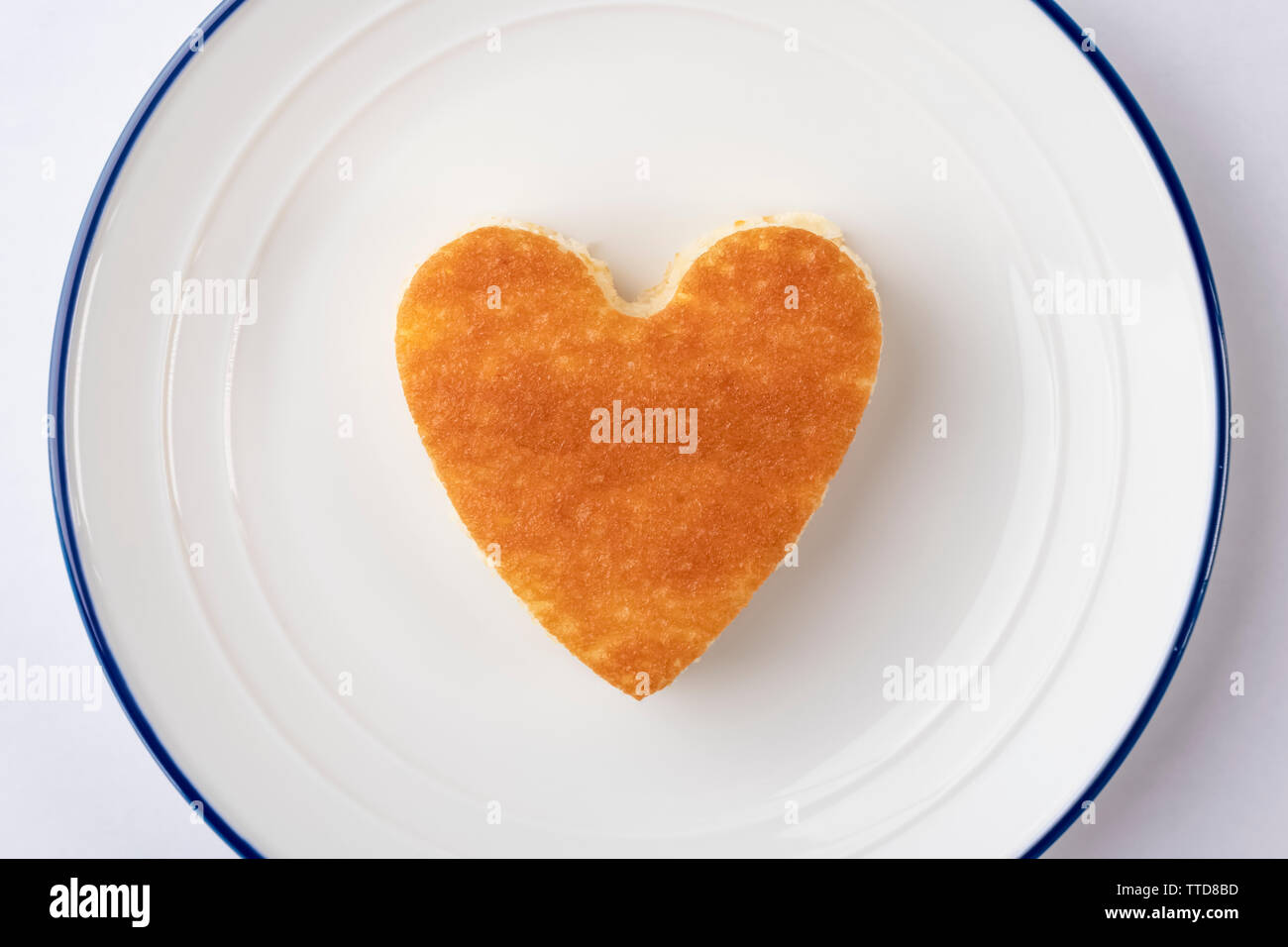 Un Petit Gateau En Forme De Cœur Sur Une Plaque Blanche Avec Une Bordure Bleue Jour De L Anniversaire Amoureux Et Concept Photo Stock Alamy